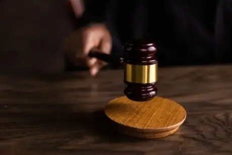 A gavel striking a sound block symbolizing justice and legal authority
