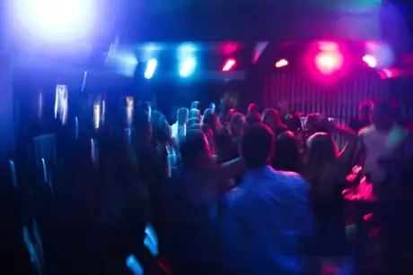 Vibrant nightclub scene with blurred dancing crowd and colorful lights
