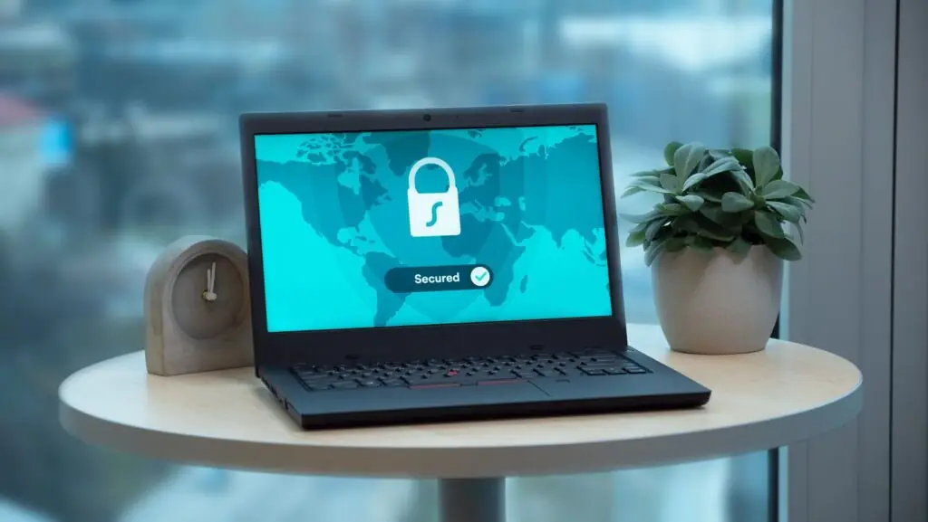 Laptop on a table displaying a glowing padlock icon and the word "Secured", illustrating cybersecurity concerns around AI-generated passwords