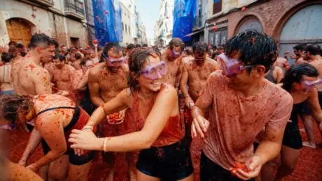 Adults wearing goggles take part in the La Tomatina tomato festival in Buñol